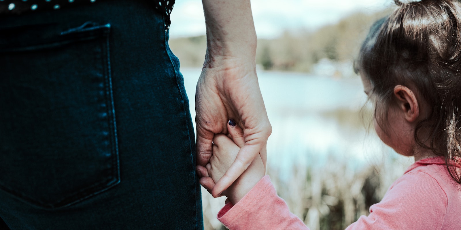 adult holding hands with a small girl