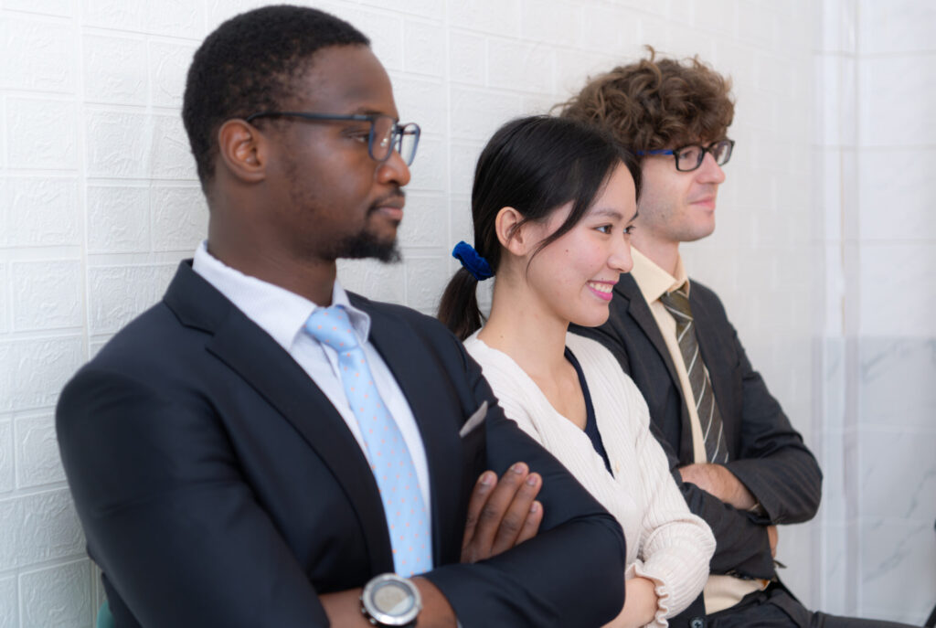 Three young professionals, arms crossed, ready to take on challenges