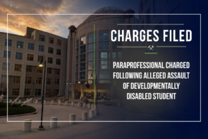 Graphic announcing criminal charges by the First Judicial District Attorney's Office. The background shows the Jefferson County Administration and Courts Building at dusk with a dark navy gradient overlay. At the top, the headline reads "Charges Filed."