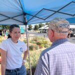 district attorney alexis king smiling as she speaks with a senior citizen at an event